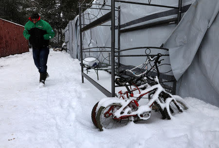 A stranded Syrian refugee braves a snowstorm at a refugee camp north of Athens, Greece January 10, 2017.REUTERS/Yannis Behrakis