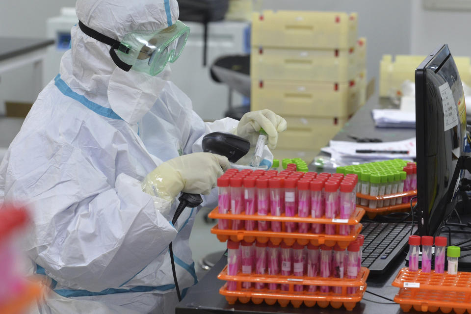 A medical worker scans the nucleic acid samples collected from a mass testing at a lab in north China's Tianjin Municipality on Monday, Nov. 23, 2020. China has reported new coronavirus cases in the cities of Shanghai and Tianjin as it seeks to prevent small outbreaks from becoming larger ones. (Chinatopix via AP)