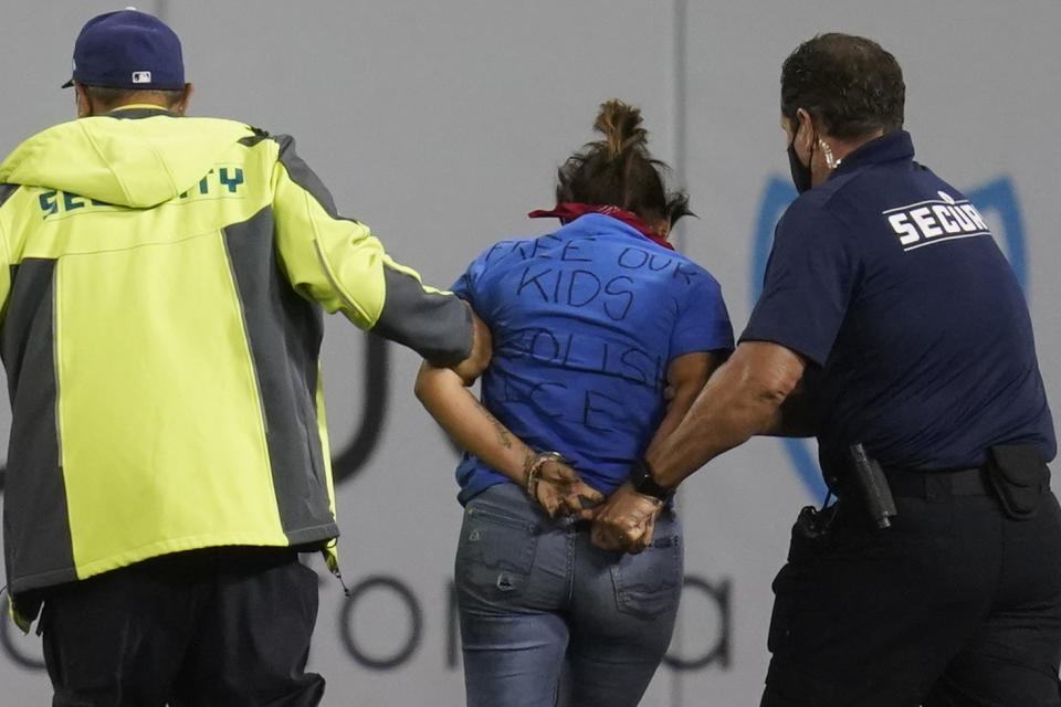 A fan who made her way on to the field is taken in to custody by security personnel during a baseball game between the Arizona Diamondbacks and the Los Angeles Dodgers Wednesday, Sept. 15, 2021, in Los Angeles. (AP Photo/Ashley Landis)