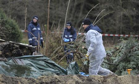 Police experts inspect the crime scene in Gimmlitztal near the town of Hartmannsdorf-Reichenau, south of Dresden, November 29, 2013. A German policeman has been arrested after the chopped-up body of a man he met on a fetishist website for cannibalism was found buried in his garden, police in the eastern city of Dresden said on Friday. REUTERS/Pawel Sosnowski