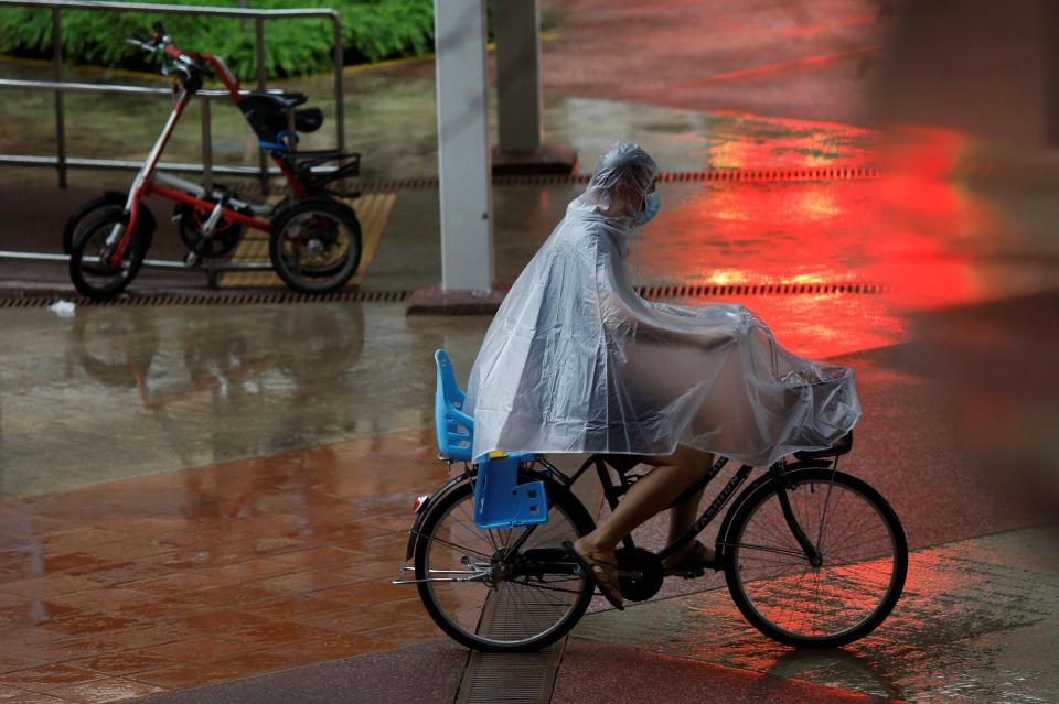 A man wearing a protective face mask rides past in a bicycle at a housing estate amid the coronavirus disease (COVID-19) outbreak in Singapore June 1, 2020.  REUTERS/Edgar Su