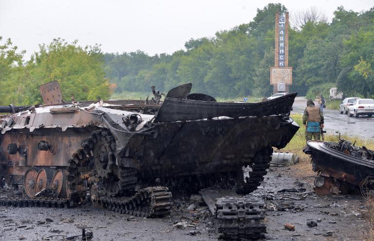 A Ukrainian soldier guards wrecked tanks and armored personnel carriers left by pro-Russian insurgents in the eastern city of Slavyansk, on July 7, 2014