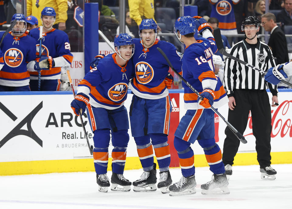 New York Islanders defenseman Ryan Pulock (6) celebrates with defenseman Mike Reilly (2) and left wing Pierre Engvall (18) after scoring against the Tampa Bay Lightning during the second period of an NHL hockey game, Thursday, Feb. 8, 2024, in New York. (AP Photo/Noah K. Murray)