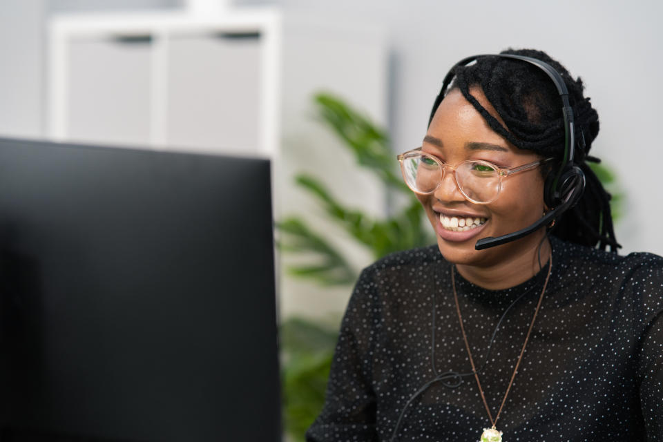 A woman wearing a headset and smiling