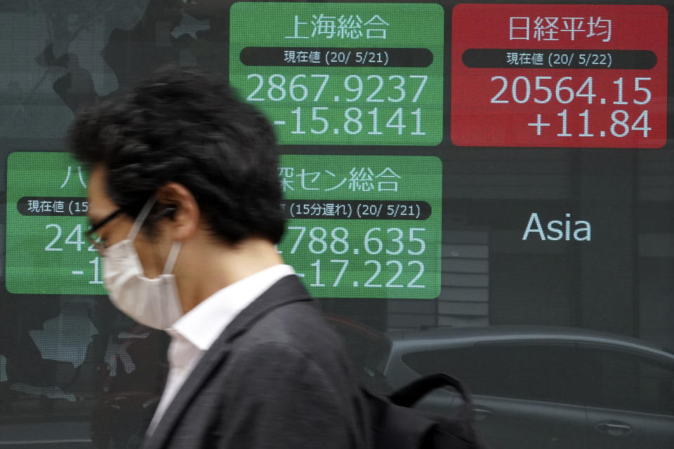 A man walks past an electronic stock board showing Japan's Nikkei 225 and other Asian indexes at a securities firm in Tokyo Friday, May 22, 2020. Shares are slipping in Asia as tensions flare between the U.S. and China and as more job losses add to the economic fallout from the coronavirus pandemic. (AP Photo/Eugene Hoshiko)