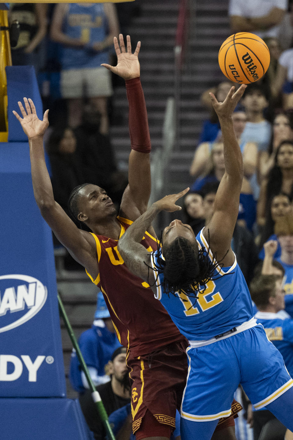 UCLA guard Sebastian Mack (12) shoots as Southern California forward Vincent Iwuchukwu (3) defends during the first half of an NCAA college basketball game Saturday, Feb. 24, 2024 in Los Angeles. (AP Photo/Kyusung Gong)