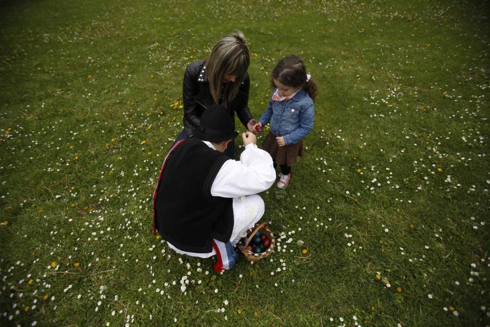 Bosnian Croat women cracks eggs with their children during the celebration of the Easter in the village of Breske, 150 kms north of the Bosnian capital of Sarajevo, on Sunday, April 20, 2014. Bosnian Croat and Bosnian Serbs celebrate Easter on a same day.(AP Photo/Amel Emric)