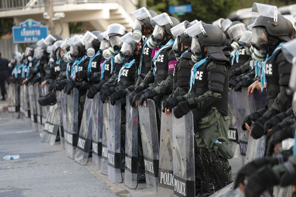 Police in riot gear stand in formation to disperse pro-democracy demonstrators near the Parliament in Bangkok, Tuesday, Nov. 17, 2020. Thailand's political battleground shifted to the country's Parliament Tuesday, where lawmakers are considering proposals to amend the country's constitution, one of the core demands of the student-led pro-democracy movement. (AP Photo/Sakchai Lalit)