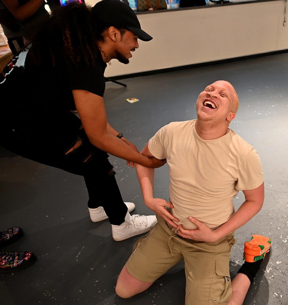 Chadd Rick, right, of Worcester, gets a hand up after dropping to the floor during his floor vogue performance last week during a Worcester PopUp! event, Vogue Worcester, at the Jean McDonough Arts Center.