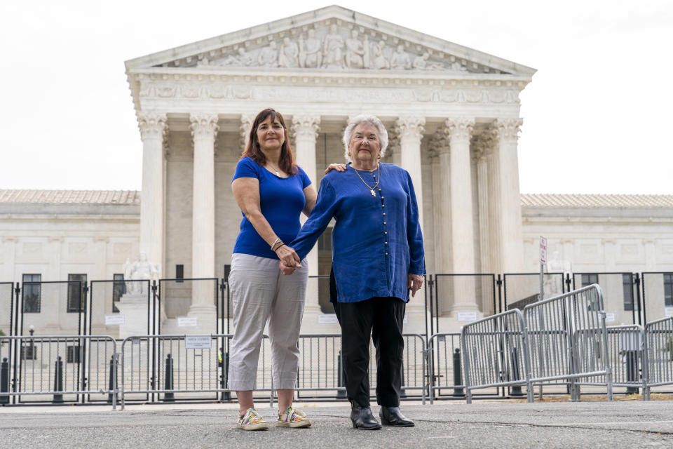 Benita Lubic, 86, of Washington, right, with her daughter Wendie Lubic, 60, pose for a photograph by the Supreme Court, Tuesday, June 21, 2022, in Washington. During a May rally in support of abortion rights, Benita Lubic came to the court with a sign saying, "I don't regret my abortion." Her daughter also had an abortion. "We weren't ready to have children or get married," says Wendie Lubic, who later did marry the same man and they have two daughters. "I had an abortion in 1968," says Benita Lubic, "three children was enough and I'm not unhappy about my decision. But I had to see a psychiatrist to get his approval, it was a sham." Lubic and her daughter came out to protest. "I want to protect children who are raped from being denied an abortion," says Benita Lubic, "I'm just sorry that Ruth Bader Ginsburg isn't alive to support us." (AP Photo/Jacquelyn Martin)