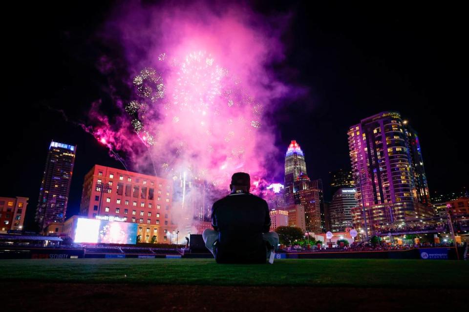 Jervay Vanderhorst, of Charlotte. N.C., records the fireworks display on his phone during SkyShow at Truist Field in Charlotte, N.C., Monday, July 4, 2022.