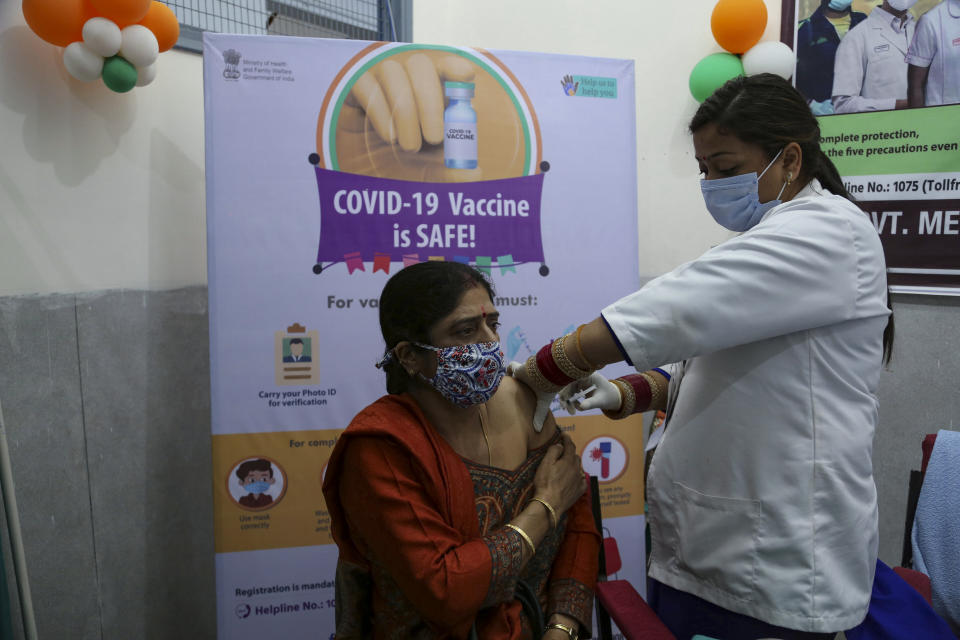 A woman receives COVISHIELD vaccine at the Government Medical College hospital in Jammu, India, Monday, March 1, 2021. India is expanding its COVID-19 vaccination drive beyond health care and front-line workers, offering the shots to older people and those with medical conditions that put them at risk. (AP Photo/Channi Anand)