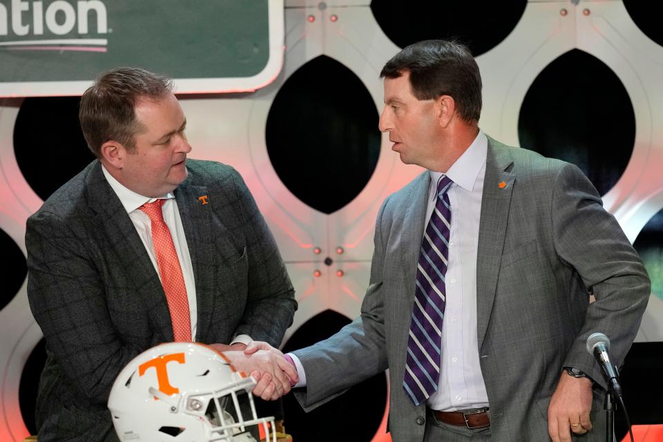 Clemson head coach Dabo Swinney, right, shakes hands with Tennessee head coach Josh Heupel, at a coaches luncheon ahead of the Orange Bowl NCAA college football game, Thursday, Dec. 29, 2022, in Miami, Fla. The two teams meet in the Orange Bowl on Friday, Dec. 30. (AP Photo/Rebecca Blackwell)