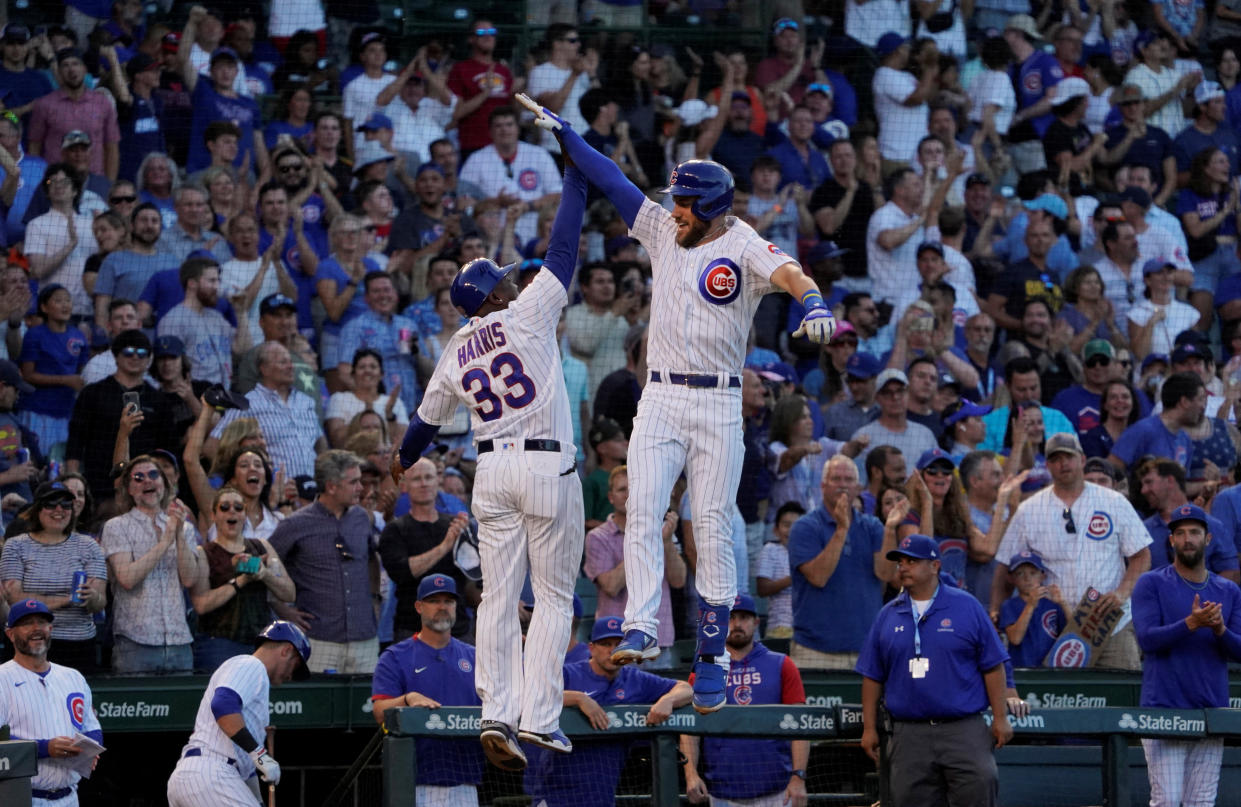 Jun 30, 2022; Chicago, Illinois, USA; Chicago Cubs third baseman Patrick Wisdom (16) is greeted by third base coach Willie Harris (33) after hitting a grand slam home run against the Cincinnati Reds during the second inning at Wrigley Field. Mandatory Credit: David Banks-USA TODAY Sports     TPX IMAGES OF THE DAY