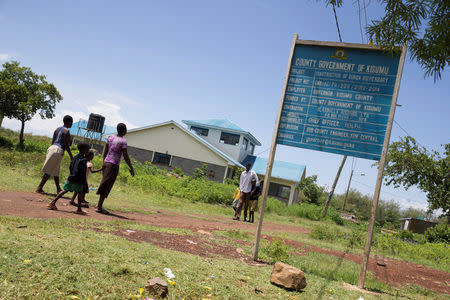 People walk past a health clinic in Dunga beach near the city of Kisumu, Kenya April 18, 2017. REUTERS/Baz Ratner