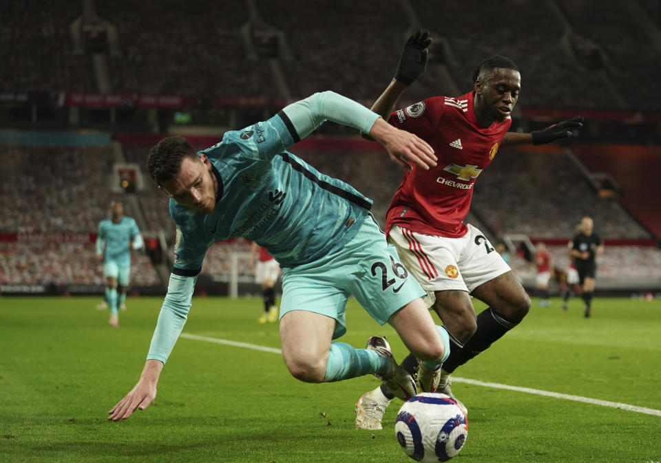 Liverpool's Andrew Robertson, left, duels for the ball with Manchester United's Aaron Wan-Bissaka during the English Premier League soccer match between Manchester United and Liverpool, at the Old Trafford stadium in Manchester, England, Thursday, May 13, 2021. (AP Photo/Dave Thompson, Pool)