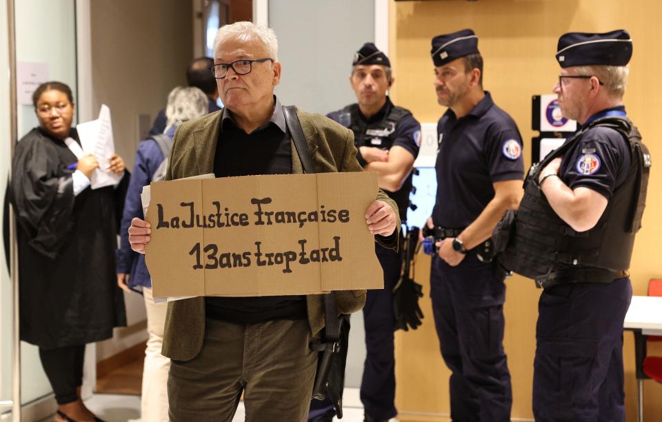 Winfried Schmidt, a German national who lost his daughter in the crash, holds a placard reading 