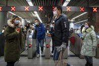 People wearing face masks to protect against the spread of the coronavirus walk through a subway station in Beijing, Wednesday, Jan. 27, 2021. China has given more than 22 million COVID vaccine shots to date as it carries out a drive ahead of next month's Lunar New Year holiday, health authorities said Wednesday. (AP Photo/Mark Schiefelbein)