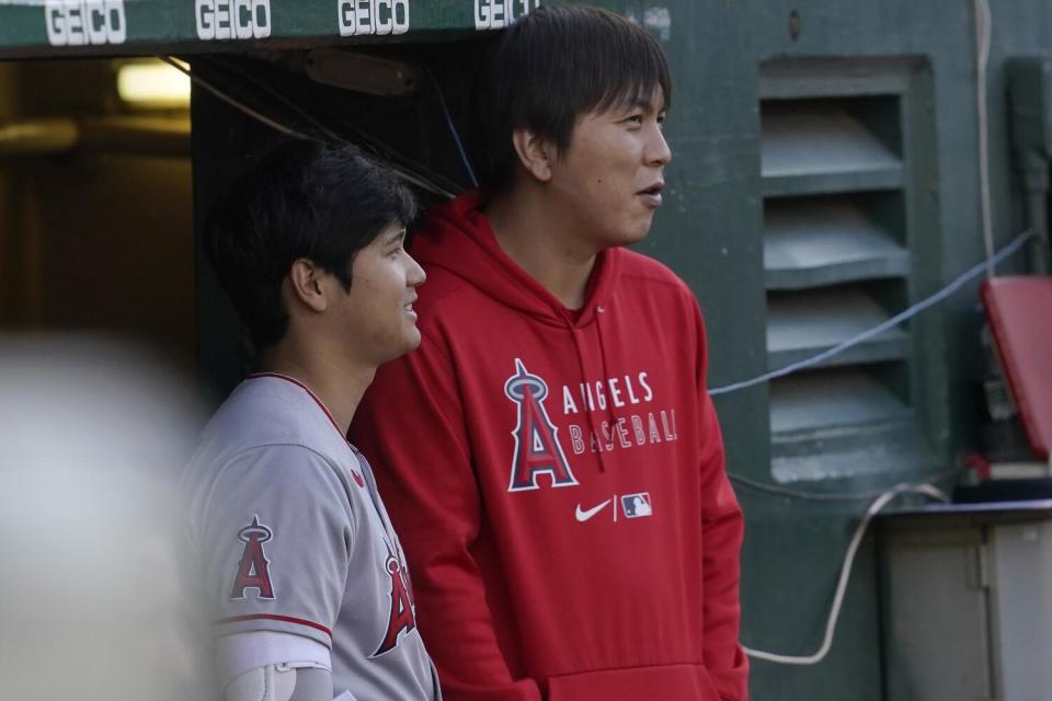 Shohei Ohtani and Ippei Mizuhara stand together during an Angels game.