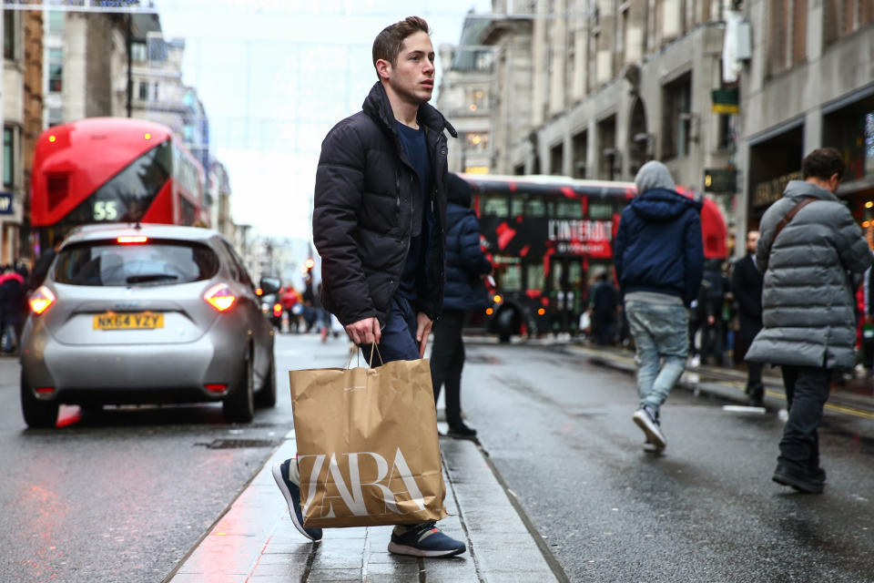 LONDON, ENGLAND - DECEMBER 26: A shopper crosses Oxford Street during the annual Boxing Day Sales on December 26, 2019 in London, England. (Photo by Hollie Adams/Getty Images)