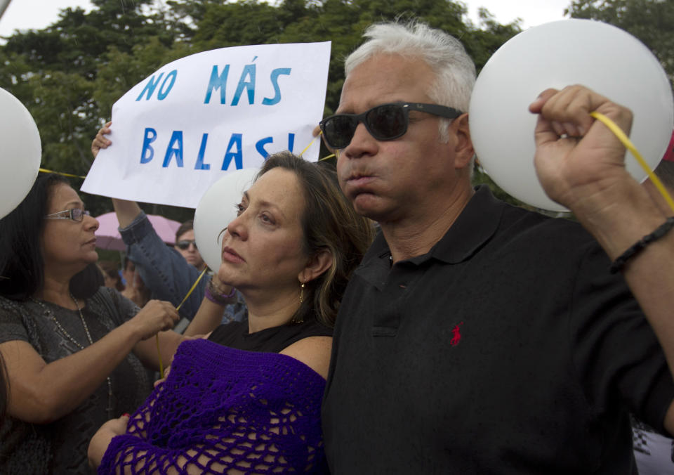 La actriz venezolana Elba Escobar, centro, y su esposo Francisco Olivares, participan en una manifestación contra la violencia en Caracas, Venezuela, el miércoles 8 de enero de 2014. La manifestación se realizó después de que la ex Miss Venezuela Mónica Spear y su ex esposo Henry Thomas Berry fueron asesinados en una carretera venezolana y su hija resultó herida en el incidente. (Foto AP/Alejandro Cegarra)