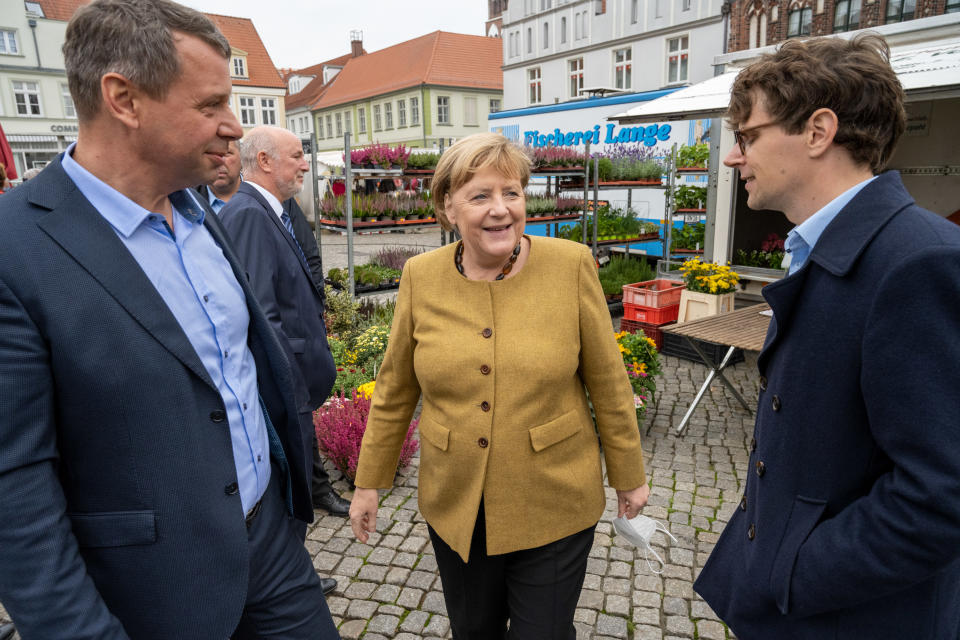 Angela Merkel mit Bundestagskandidat Georg Günther (r) und Landtagskandidat Michael Sack (l) auf dem Wochenmarkt (Bild: Stefan Sauer/dpa)