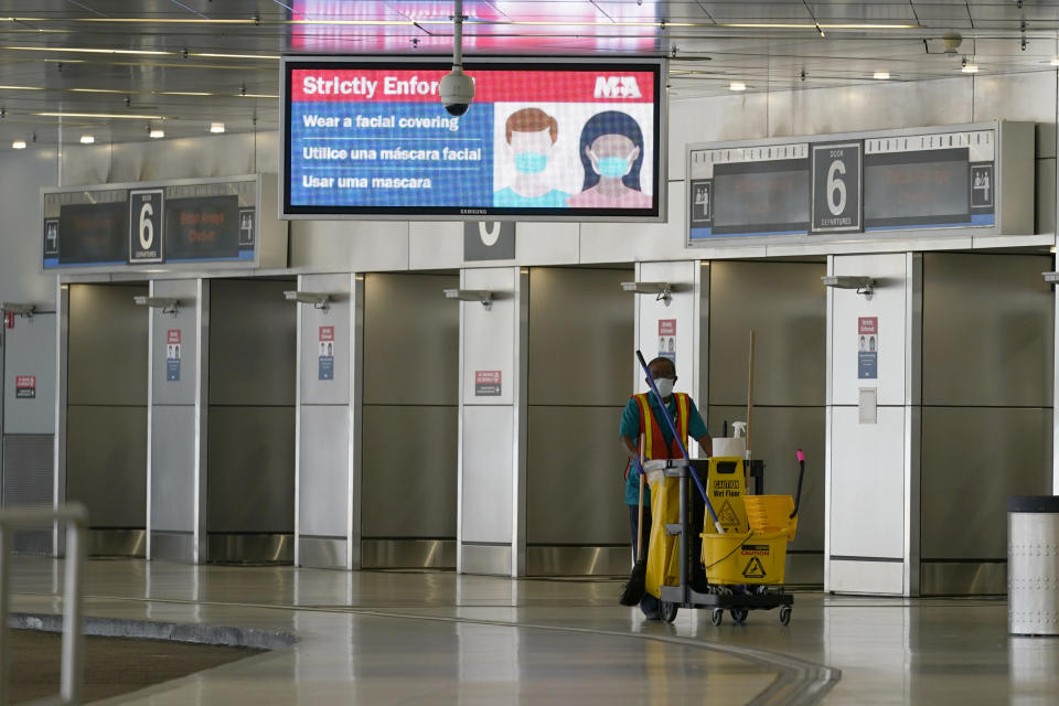 FILE - In this Sept. 30, 2020, file photo, an employee walks through an empty American Airlines arrivals area at Miami International Airport during the coronavirus pandemic in Miami. President Donald Trump’s startling COVID-19 diagnosis serves as a cruel reminder of the pervasive spread of the coronavirus in the United States and shows how tenuous of a grip the nation has on the crisis, health experts said. (AP Photo/Lynne Sladky, File)