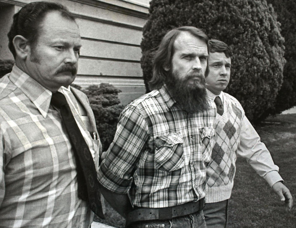 PROVO, UT - APRIL 25, 1985:  (FILE PHOTO) Ron Lafferty (C) is escorted out of the Utah County Court House by Utah County Sheriff Deputies after the first day of jury selection in his murder trial April 25, 1985 in Provo, Utah. Lafferty and his brother Dan were convicted for the July 1984 murder of Lafferty's sister-in-law and her 15-month-old daughter, which he said was an order from God. The brothers were members of a fundamentalist Mormon splinter group who embraced polygamy, the superiority of the white race, the end of the world and the right to commit murder in the name of God. Dan Lafferty and his brothers were excommunicated by the mainstream Mormon Church. Lafferty and the fundamentalist Mormons are chronicled in Jon Krakauer's new book 
