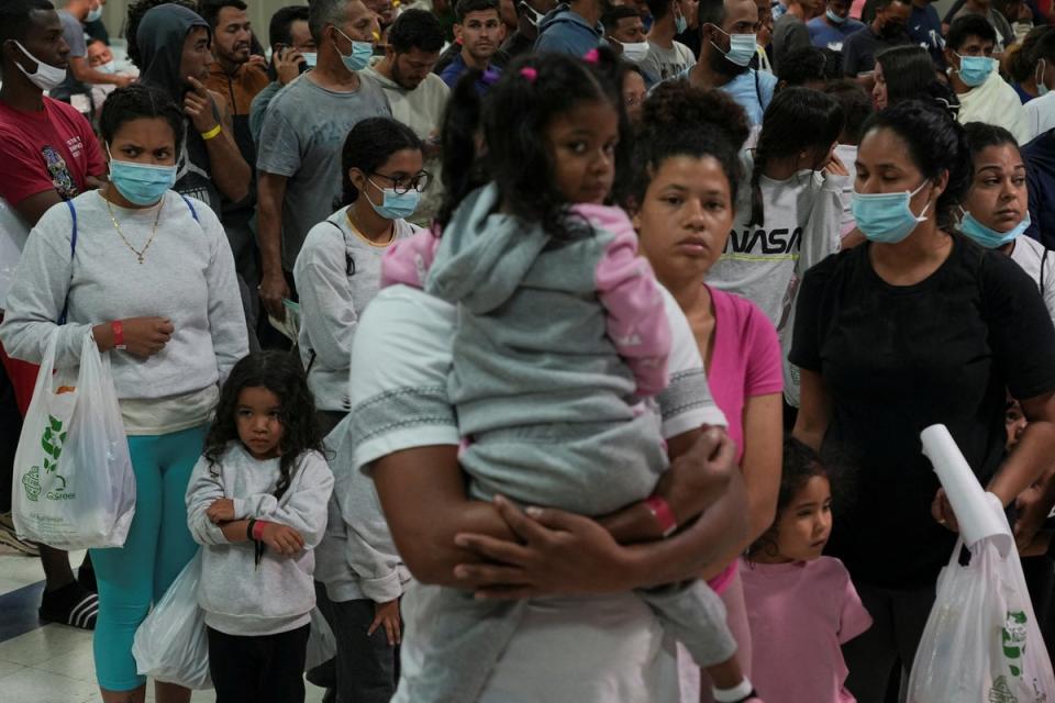 People seeking asylum in the US wait in line before boarding buses to New York and Chicago from El Paso, Texas on 3 October (REUTERS)