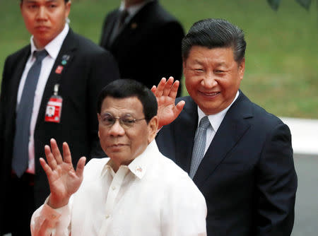 Visiting Chinese President Xi Jinping and Philippine President Rodrigo Duterte wave to the media before their one on one meeting at the Malacanang presidential palace in Manila, Philippines, November 20, 2018. REUTERS/Erik De Castro