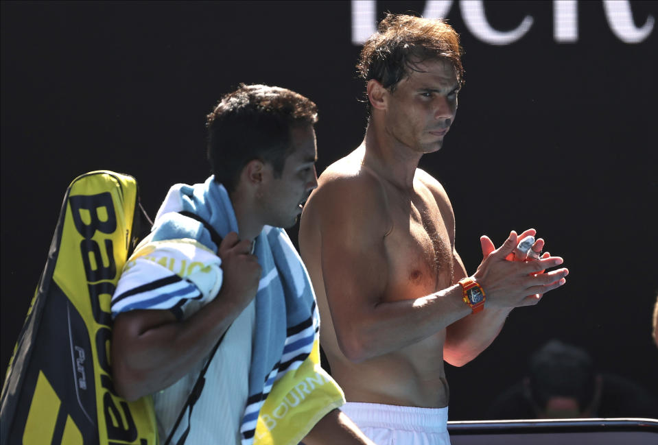 Spain's Rafael Nadal, right, applauds as his opponent Bolivia's Hugo Dellien leaves Rod Laver Arena following their first round singles match at the Australian Open tennis championship in Melbourne, Australia, Tuesday, Jan. 21, 2020. (AP Photo/Lee Jin-man)
