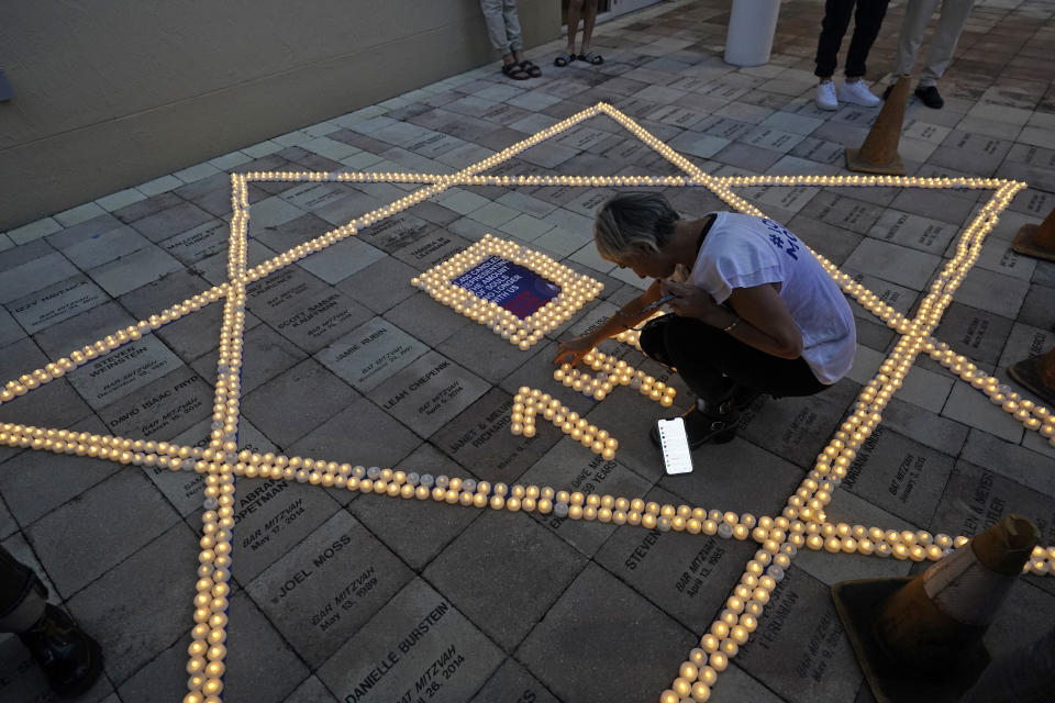 Etti Ifargan arranges flameless candles during an empty Shabbat table event honoring those kidnapped by Hamas in Israel, Thursday, Nov. 2, 2023, at Temple Beth Sholom in Miami Beach, Fla. The holiday of Hanukkah, Judaism's festival of lights, will be both more needed and more poignant than ever this year, say Jews from across the religious observance and political spectrum in Miami Beach and neighboring South Florida communities. (AP Photo/Wilfredo Lee)