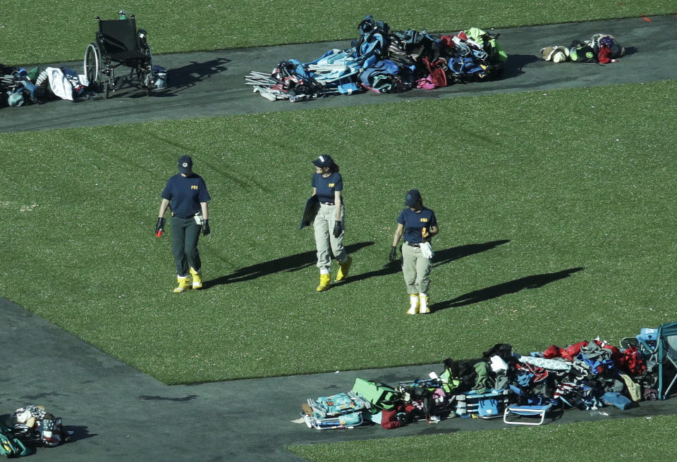 <p>Members of the FBI walk among piles of personal items at the scene of a mass shooting Friday, Oct. 6, 2017, in Las Vegas. (Photo: John Locher/AP) </p>