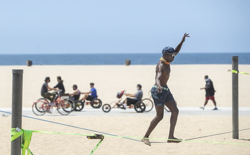 SANTA MONICA, CA - JUNE 29: Jacob Laiser, 38, of Venice, balances on a slack line, while working out at Santa Monica Beach on Monday, June 29, 2020 in Santa Monica, CA. L.A. County is expected to reach 100,000 cases of coronavirus.