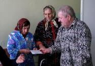 Local residents read a ballot during a presidential election at a hospital in the village of Kozhushna, outside Chisinau, Moldova, October 30, 2016. REUTERS/Gleb Garanich