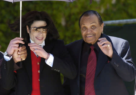 FILE PHOTO: Pop star Michael Jackson and his father Joe Jackson gestures to his fans as he leaves the Santa Barbara county courthouse in Santa Maria, California. REUTERS/Phil Klein/File Photo