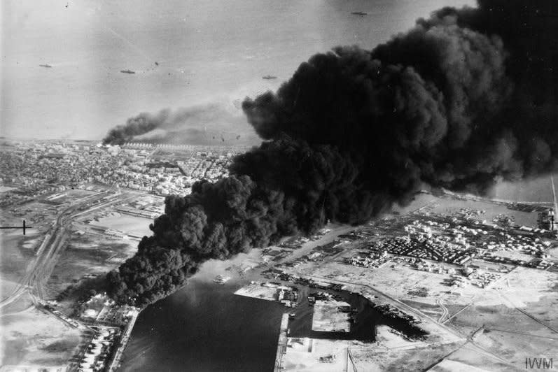 Smoke rises from oil tanks beside the Suez Canal hit during the initial Anglo-French assault on Port Said, on November 6, 1956. On October 29, 1956, Israeli forces, in a plan later found to have been coordinated with Britain and France, invade the Sinai Peninsula, pushing Egyptian forces back to the Suez Canal. The Suez Crisis, which lasted just over a week, would keep the waterway closed from October 1956 until March 1957. File Photo courtesy Imperial War Museum
