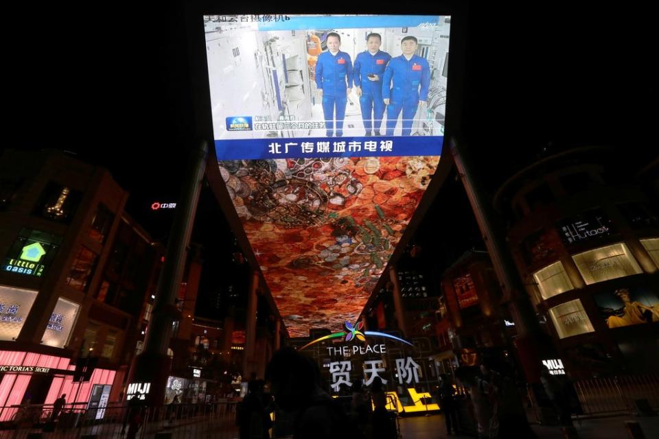 A giant screen shows a news broadcast of the astronauts of the Shenzhou-12 mission inside the core module Tianhe of the Chinese space station, before returning to Earth (REUTERS)