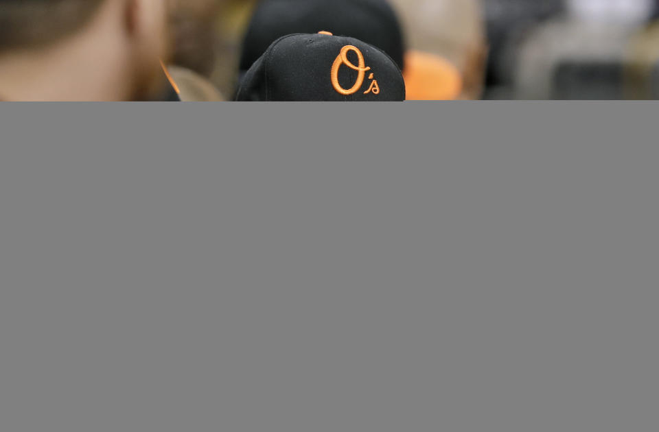 Baltimore Orioles pitcher David Hess sits along the dugout rail during the first inning of a baseball game against the Tampa Bay Rays Friday, Sept. 7, 2018, in St. Petersburg, Fla. Hess was hit in the eye with a football while warming up before the game. (AP Photo/Chris O'Meara)