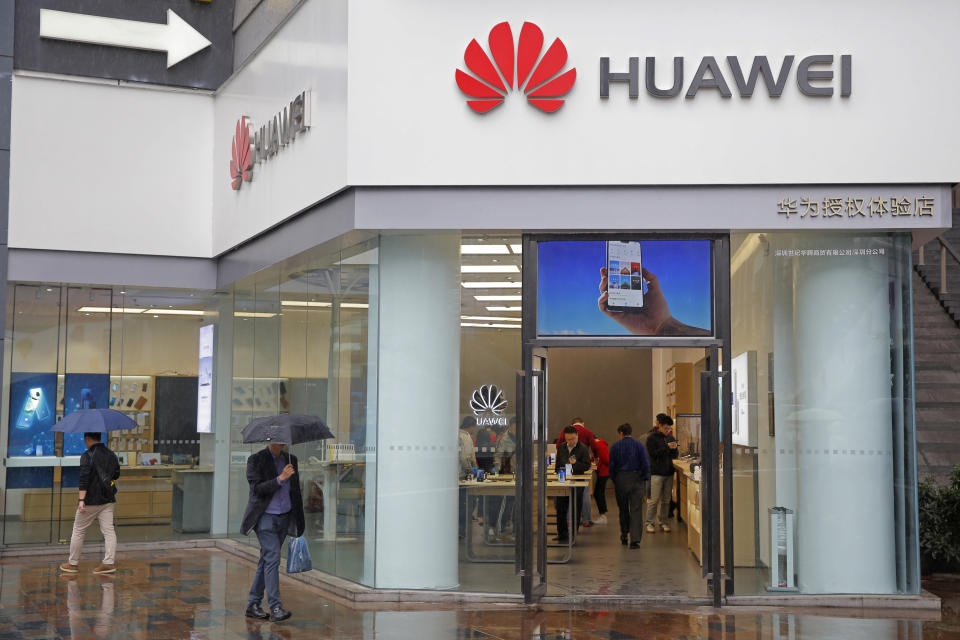 People walk past a Huawei retail shop in Shenzhen, China's Guangdong province, Thursday, March 7, 2019. Chinese tech giant Huawei is challenging a U.S. law that labels the company a security risk and would limit its access to the American market for telecom equipment. (AP Photo/Kin Cheung)