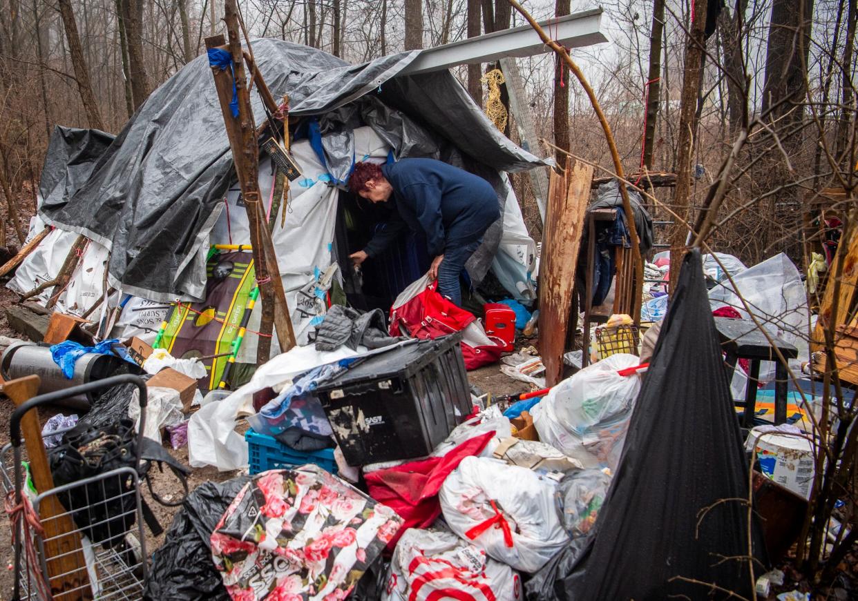 Kay, who is homeless, gathers belongings from an encampment near Wheeler Mission the city of Bloomington cleared last month.