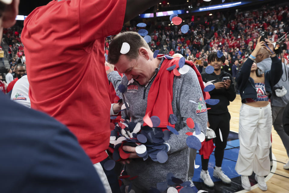 Arizona center Oumar Ballo, left, dumps confetti onto coach Tommy Lloyd while celebrating the team's win over UCLA in an NCAA college basketball game for the championship of the men's Pac-12 Tournament Saturday, March 11, 2023, in Las Vegas. (AP Photo/Chase Stevens)