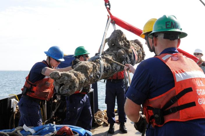 US Coast Guard members help raise a cannon from a sunken ship off the coast of North Carolina in 2013 (AFP Photo/Karen A.Blum)