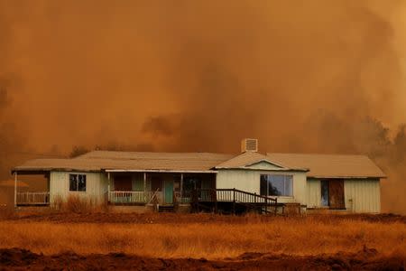 A home stands amidst smoke from the Detwiler fire in Mariposa, California U.S. July 19, 2017. REUTERS/Stephen Lam