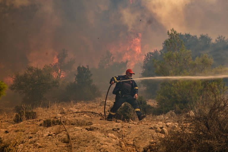 Un bombero huye de un incendio forestal en Kandyli, un asentamiento cerca de Nea Peramos, al oeste de Atenas