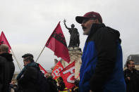 Protesters walk past the statue on the Place de la Republique during a demonstration Thursday, Dec. 19, 2019 in Paris. Traffic improved slightly on French trains Thursday as nationwide strikes over the government's retirement reform entered a 15th day and small signs of progress emerged in negotiations with unions. (AP Photo/Michel Euler)