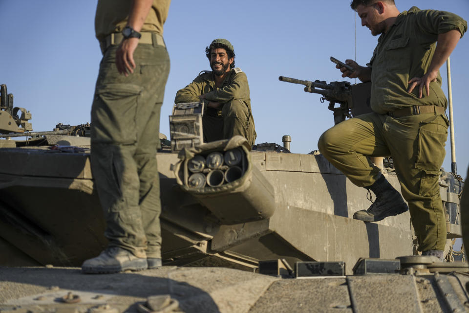 Israeli soldiers on their tank near the Israeli-Gaza border, in southern Israel, Wednesday, June 5, 2024. (AP Photo/Tsafrir Abayov)