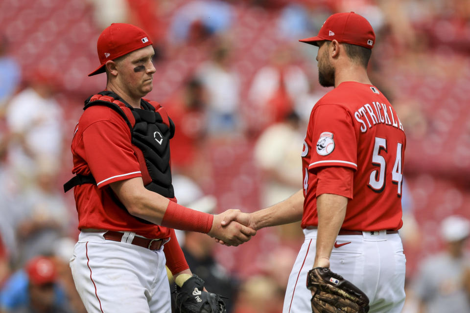 Cincinnati Reds' Michael Papierski, left, shakes hands with Hunter Strickland after the final out of a baseball game against the St. Louis Cardinals in Cincinnati, Sunday, July 24, 2022. (AP Photo/Aaron Doster)
