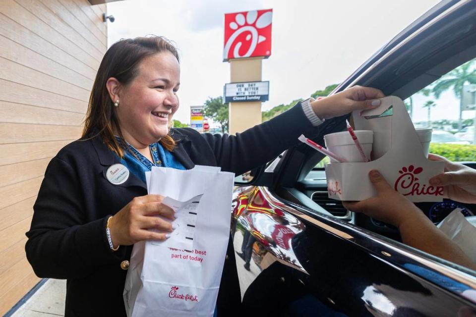 Cynthia Bowles serves drive-thru customers outside the Chick-fil-A she runs in Hialeah.