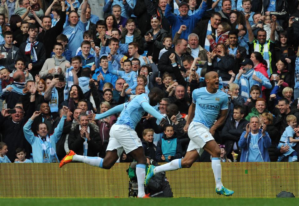 Manchester City's Vincent Kompany, right, celebrates after scoring against West Ham during the English Premier League soccer match between Manchester City and West Ham United at the Etihad Stadium, Manchester, England, Sunday, May 11, 2014. (AP Photo/Rui Vieira)